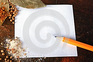 Note and spices on a wood cutting board