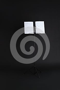 Note stand with music sheets on black