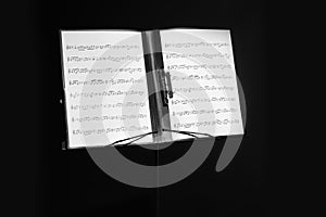 Note stand with music sheets on black