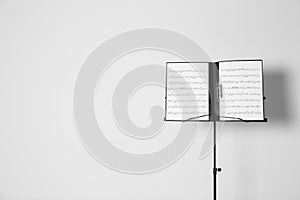 Note stand with music sheets on white background.