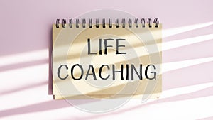 Note with words life coach on a pink
