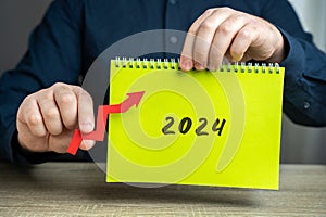 Notebook 2024 and up arrow. The forecast concept for new year.