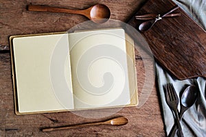 Notebook amd wooden utensil in kitchen on old wooden background