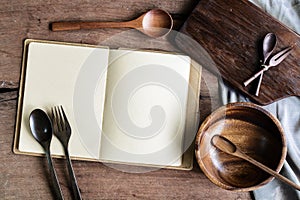 Notebook amd wooden utensil in kitchen on old wooden background