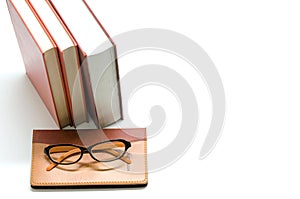 Notebook,books and glasses on white background