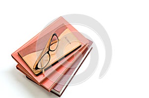 Notebook,books and glasses on white background