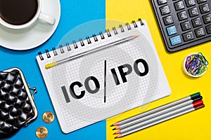 A Notebook with Business notes initial coin offering ICO vs IPO Initial Public Offering with office tools photo