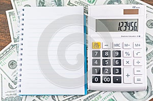 Notebook and calculator on dollar bill background