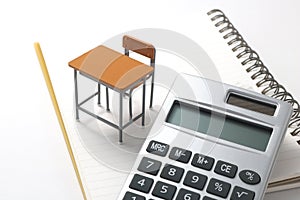 Notebook, calculator, pencil and miniature desk