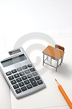 Notebook, calculator, pencil and miniature desk