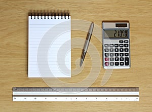 Notebook calculator ruler and pen on desk