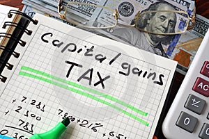 Notebook with capital gains tax sign on a table. photo