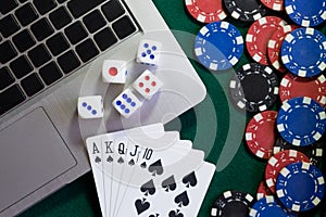 Notebook, cards, dice and chips on green baize. Online casino always there.