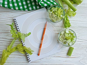 Notebook celery on wooden backgroundn vitamin food photo