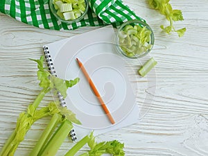 Notebook celery  vegan on wooden backgroundn vitamin food photo