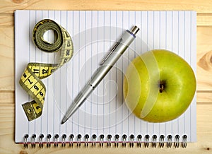 Notebook with centimeter and apple fruit