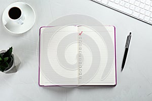 Notebook with checkboxes, cup of coffee and plant on white table, flat lay. Checklist