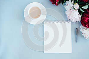 Notebook and coffee on blue background