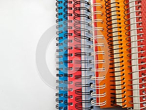 Notebook color - pink, orange, blue. Spiral notebook. Isolated on a white background. Stack of colorful copybooks.