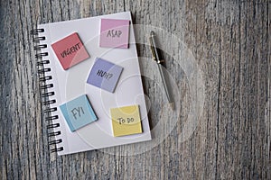 Notebook covered in post it notes, taken on a wooden background