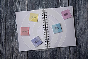 Notebook covered in post it notes, taken on a wooden background