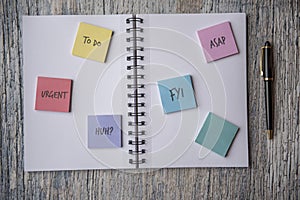 Notebook covered in post it notes, taken on a wooden background