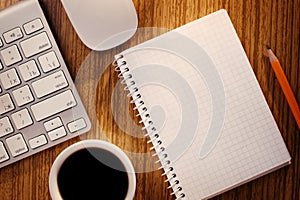 Notebook and Cup of Coffee near Computer Keyboard