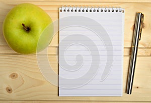 Notebook with fountain pen and apple fruit