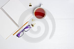Notebook, glasses, pencil and coffee on white background.