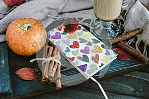 Notebook with hearts, pumpkin, cinnamon and leaves. Autumn conce