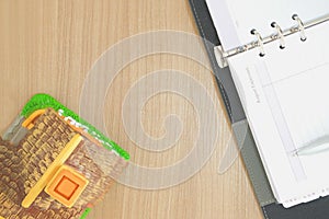 notebook & house model on wooden desk. realtor real estate agent