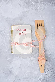 Notebook with inscription ash diet and wooden spoon and spatula  wrapped in centimeters.Culinary blog  recipe template  online