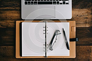 Notebook, laptop, pen, spectacles on wooden table