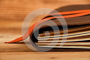 Notebook in leather cover on wooden table