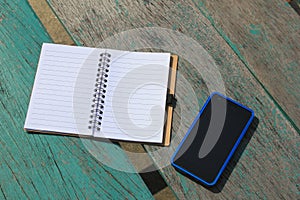 Notebook and mobile phone on the green table