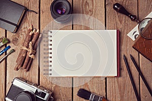 Notebook mock up for artwork or logo design presentation with film camera and lens. View from above