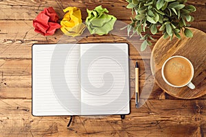 Notebook mock up with coffee cup and plant on wooden office desk.