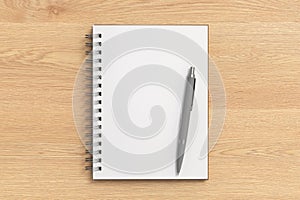 Notebook mockup. Opened blank notebook and pen. Spiral notepad on wooden background