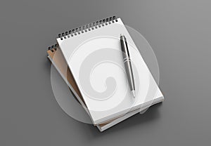 Notebook mockup. Two notebooks in a stack and pen. Spiral notepad on gray background