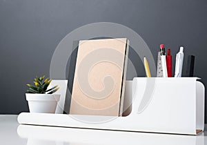 Notebook on modern office stationery on white table.pencil, notepad,ruler,pen and pencil box with plant.Mock up paper note for