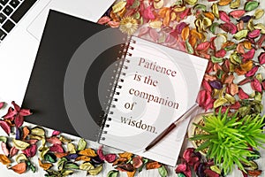 Notebook with motivational quote on background with dry flower petals.