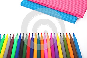 Notebook and multicolored markers on a white background