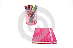 Notebook and multicolored markers on a white background