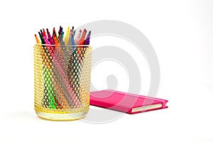 Notebook and multicolored markers on a white background