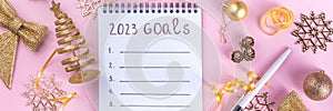 Notebook with New`s Year Resolutions massage, with Christmas ornaments and decor. New Year goals List 2023, plan listing of new