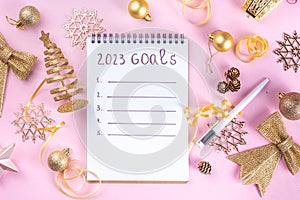 Notebook with New`s Year Resolutions massage, with Christmas ornaments and decor. New Year goals List 2023, plan listing of new