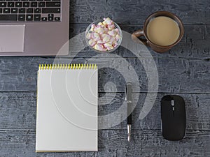 Notebook, notebook, pen, coffee Cup and marshmallow on the dark wooden table.