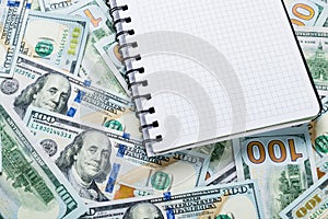 Notebook for notes lying on money background from dollars