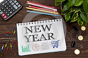 Notebook with a notes NEW YEAR on the office table with tools. C