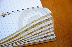 The notebook is open on the wooden empty table